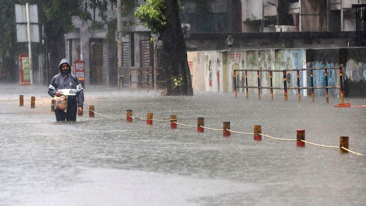 A man wades through a waterlogged road after heavy rainfall in Mumbai. Credit: Reuters Photo