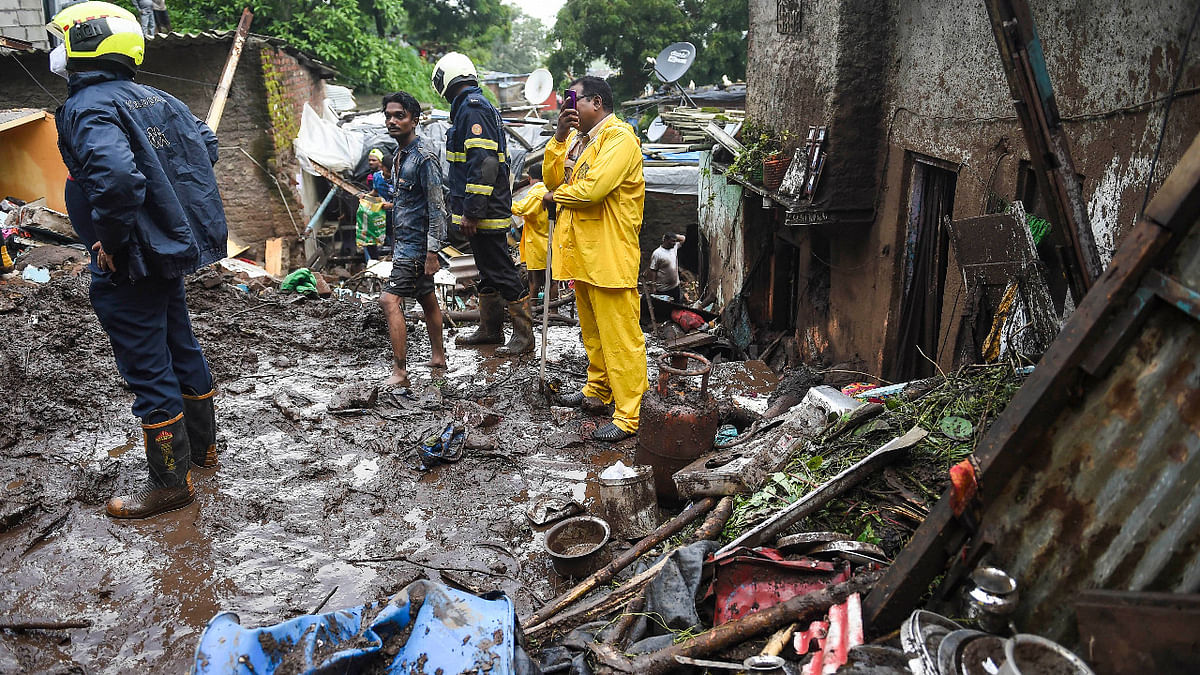 Firemen and rescue workers in action after a wall collapsed on some shanties in Chembur's Bharat Nagar area due to a landslide, in Mumbai. Credit: PTI Photo