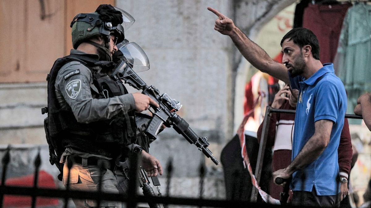 A Palestinian man argues with Israeli border guards blocking a street for a procession of religious Jews in Hebron. Credit: AFP Photo