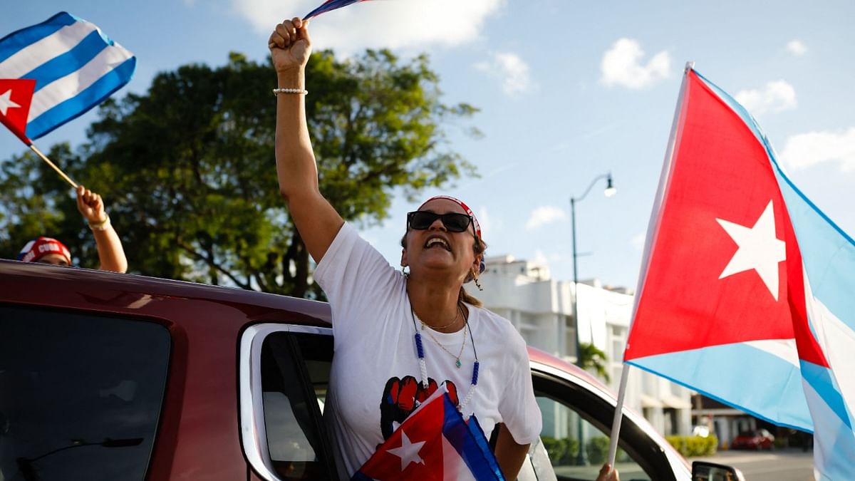 A woman holds a Cuban flag during a protest showing support for Cubans demonstrating against their government, at Versailles Restaurant in Miami. Credit: AFP Photo
