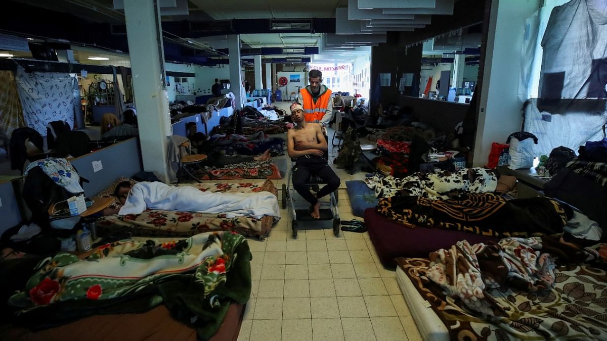 Yassine Azhari, 24, an asylum seeker from Morocco who is among several hundred migrants requesting to be regularised by the Belgian government to have access to healthcare, is taken back to his mattress  at the ULB University campus in Brussels. Credit: Reuters Photo