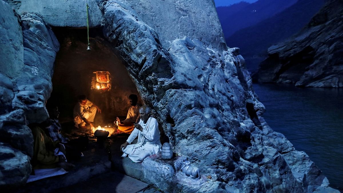 Photo of Hindu priests perform evening prayers inside a cave on the banks of Ganges in Devprayag. Credit: Reuters/ Danish Siddiqui