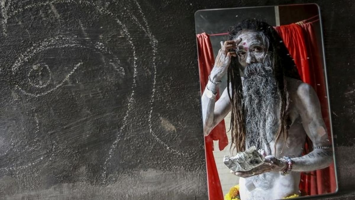 A Naga sadhu is seen applying ash as he gears up for a procession at the Kumbh Mela. Credit: Reuters/ Danish Siddiqui