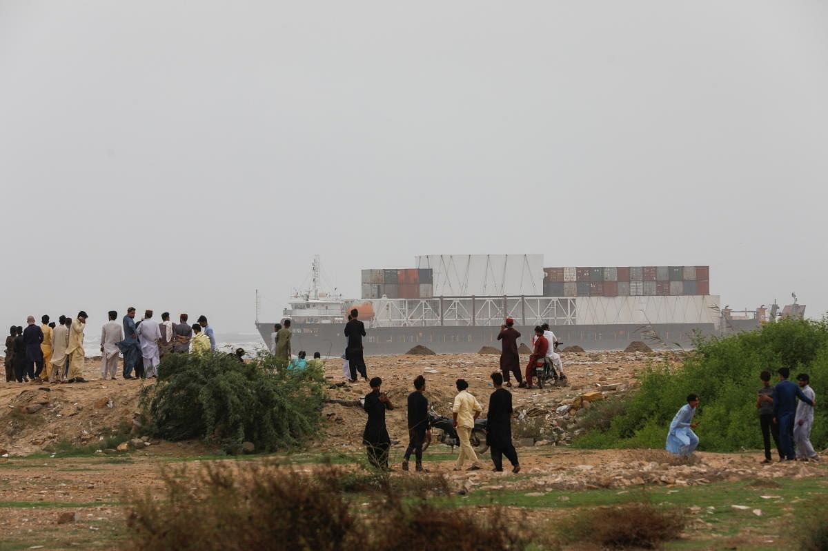 People gather as a cargo ship Heng Tong 77 is seen stranded near Sea View beach in Karachi, Pakistan. Credit: Reuters Photo