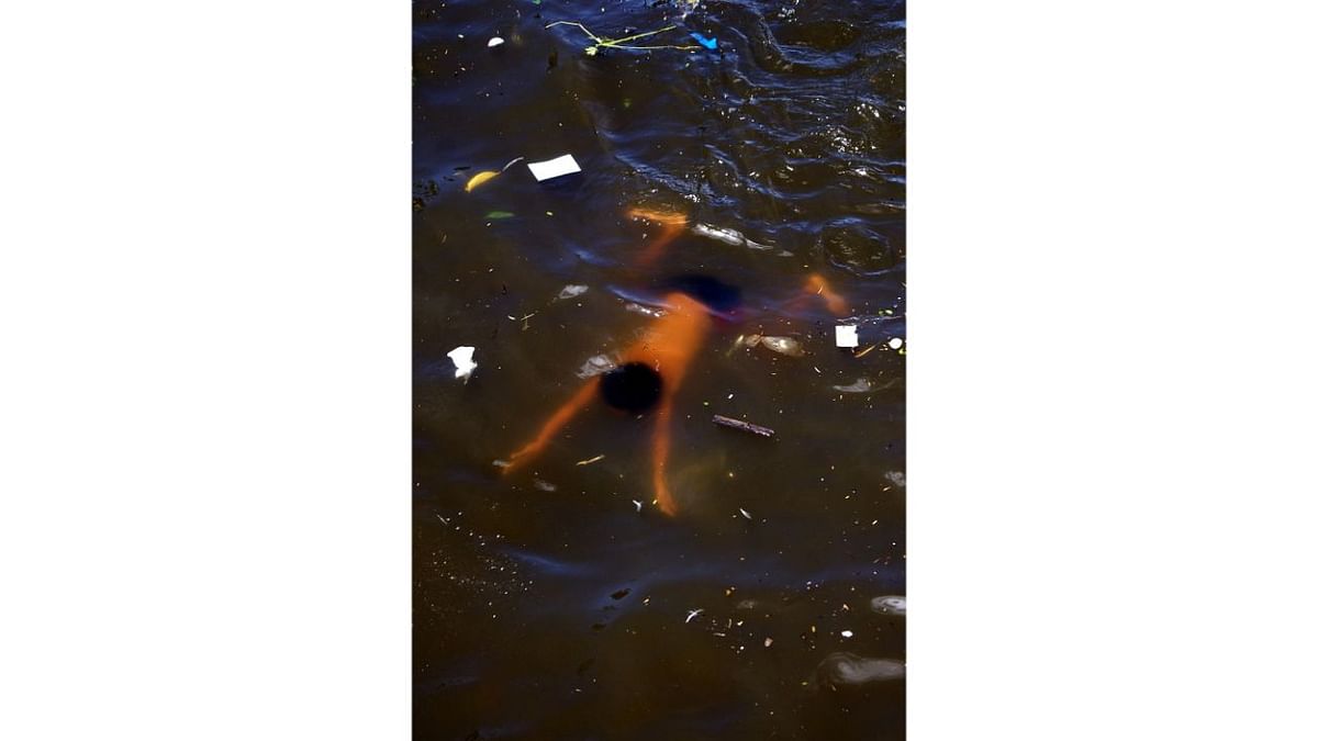 A youngster swims in a river polluted with plastic and other waste in Bocaue, Philippines. Photo by Jophel Botero Ybiosa (Philippines)