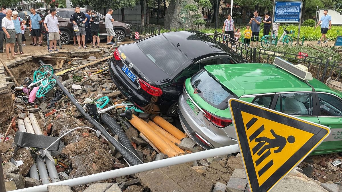 Damaged cars rest on debris after heavy rains hit the city of Zhengzhou causing floods in Central China. Credit: AFP Photo