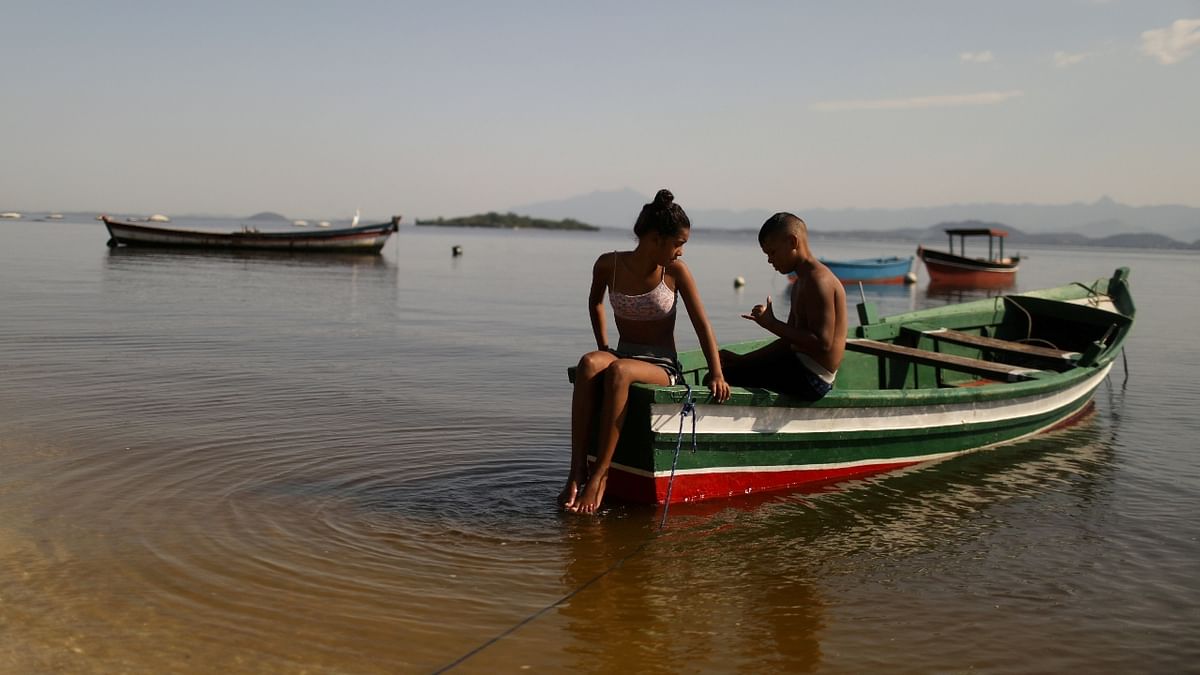 Youths rest on a boat in Paqueta island during the mass vaccination against the coronavirus disease. Credit: Reuters Photo