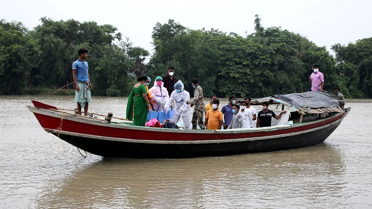 Healthcare workers are seen crossing Mundeswari river in a boat to inoculate villagers with Covishield vaccine in West Bengal. Credit: Reuters Photo