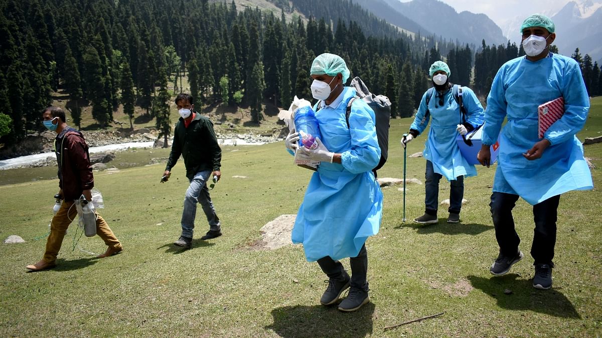 Healthcare workers reach to a forest area to inoculate shepherds with a coronavirus disease during a vaccination drive in Pulwama, south Kashmir. Credit: Reuters Photo