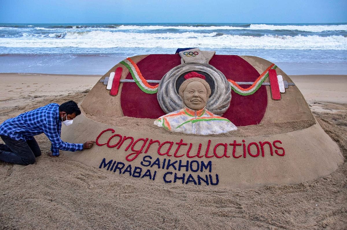 Sand artist Sudarsan Pattnaik congratulates weightlifter Mirabai Chanu for winning silver medal at Tokyo olympics, at Puri beach in Odisha. Credit: PTI Photo