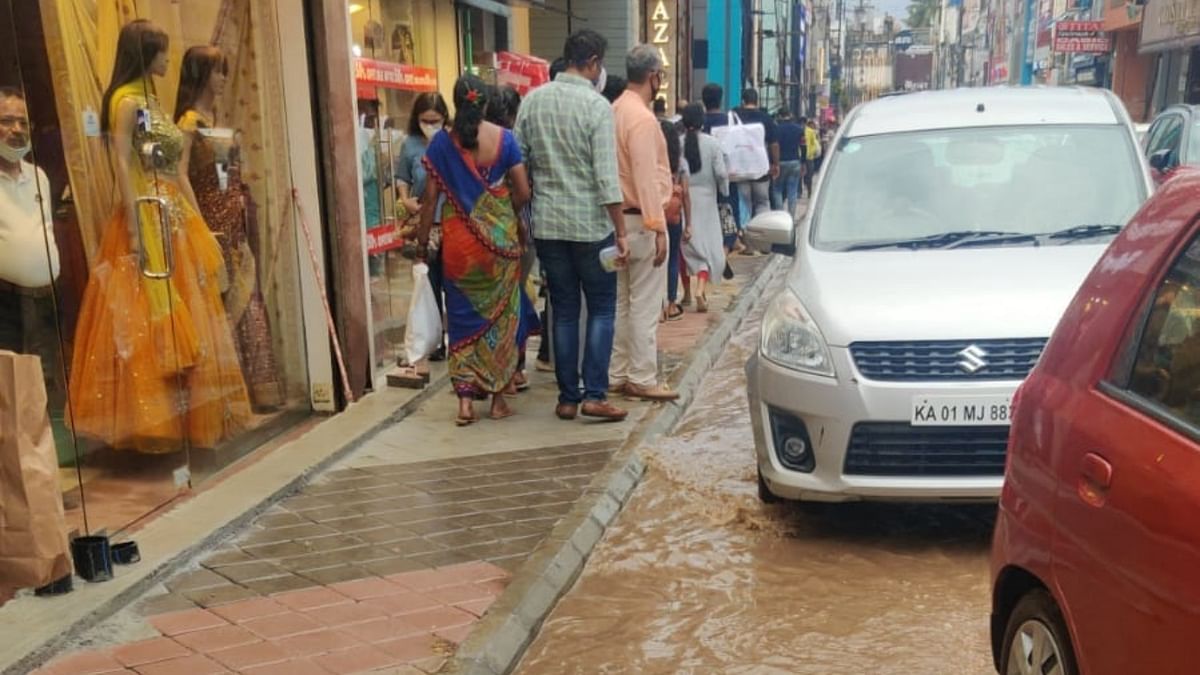 Commuters pass through water logged street in Bengaluru. Credit: DH Photo