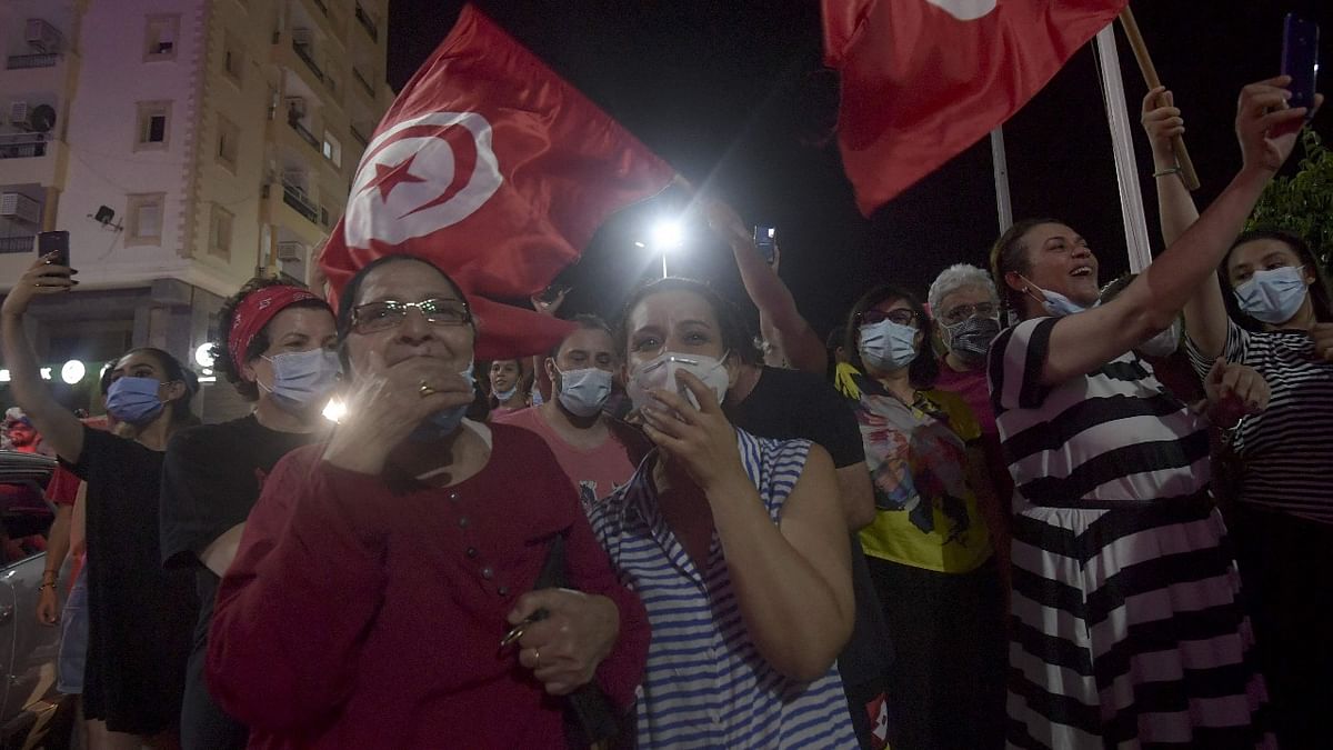 People celebrate in the street after Tunisian President Kais Saied announced the dissolution of parliament and Prime Minister Hichem Mechichi's government in Tunis on July 25, 2021, after a day of nationwide protest. Credit: AFP Photo