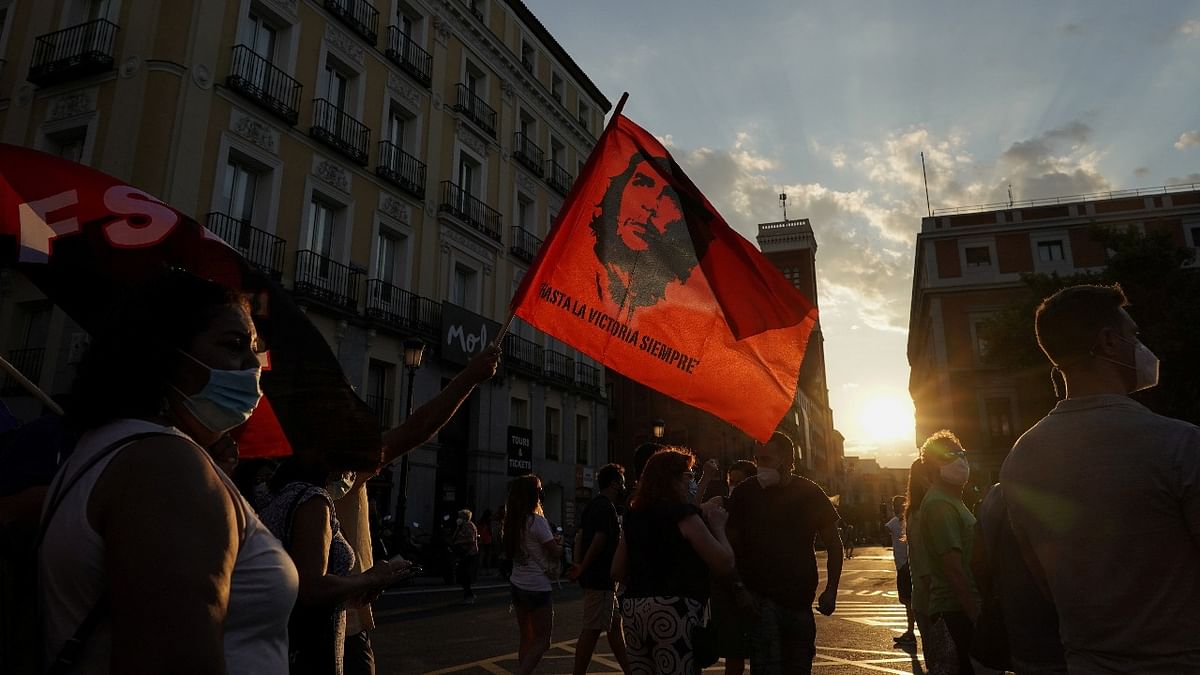 A demonstrator holds a flag with the image of Che Guevara that reads