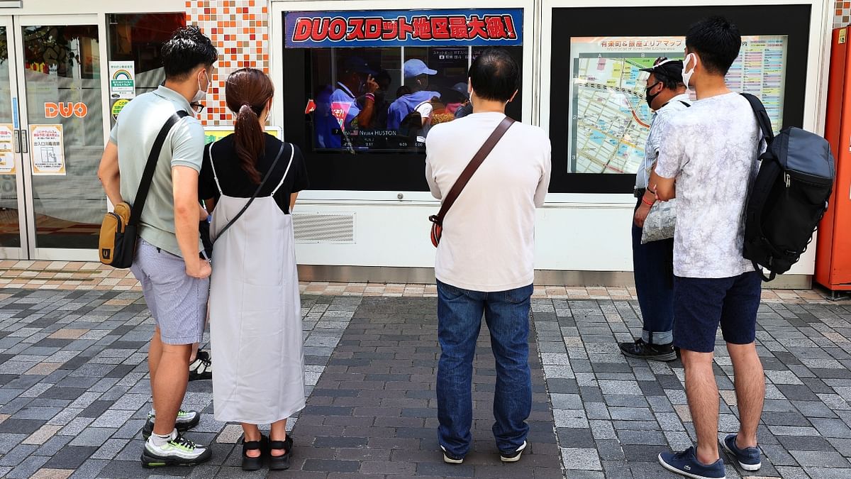 People watch a TV broadcast of skateboarding competition during the 2020 Tokyo Olympic Games, in Tokyo. Credit: Reuters Photo