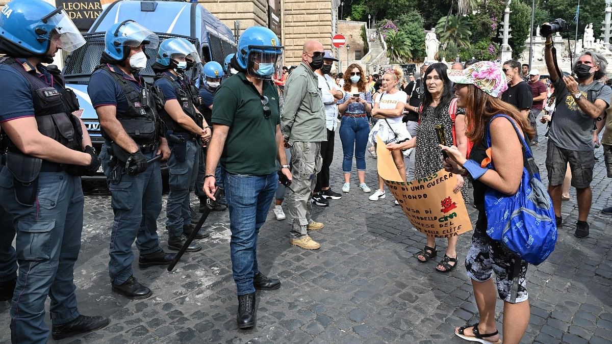 Protestors interact with police officers during a demonstration against the introduction of a mandatory