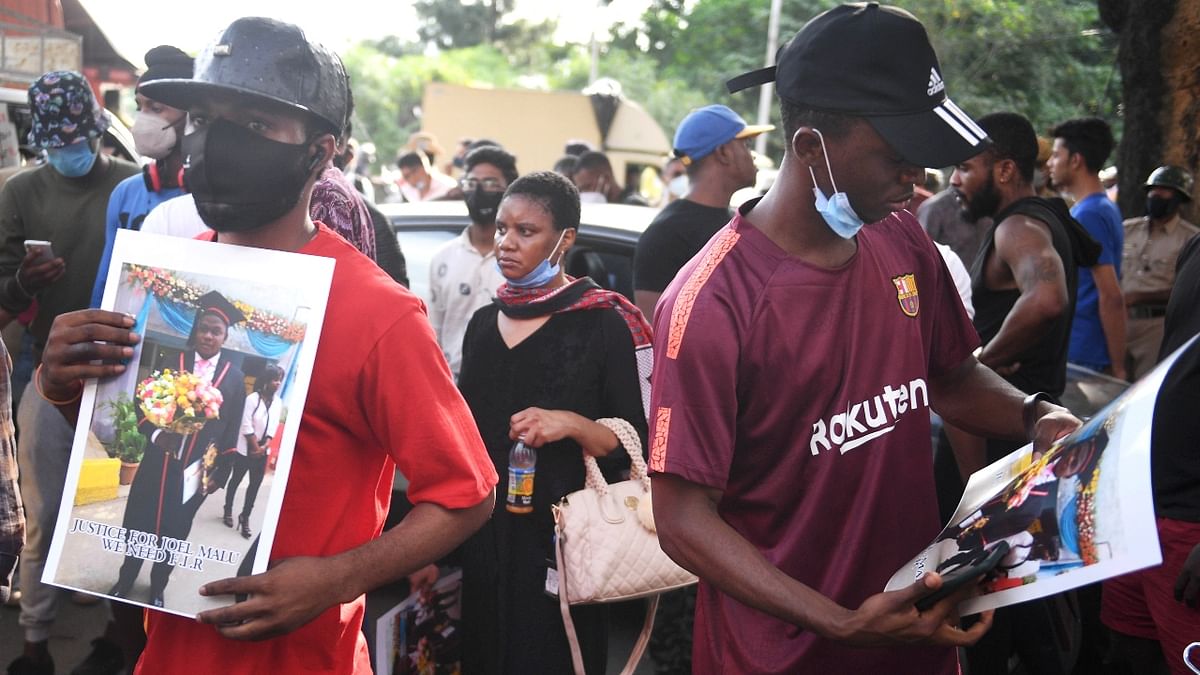 African nationals are seen with posters of Joel Malu, who allegedly died in police custody after suffering a cardiac arrest. Credit: PTI Photo
