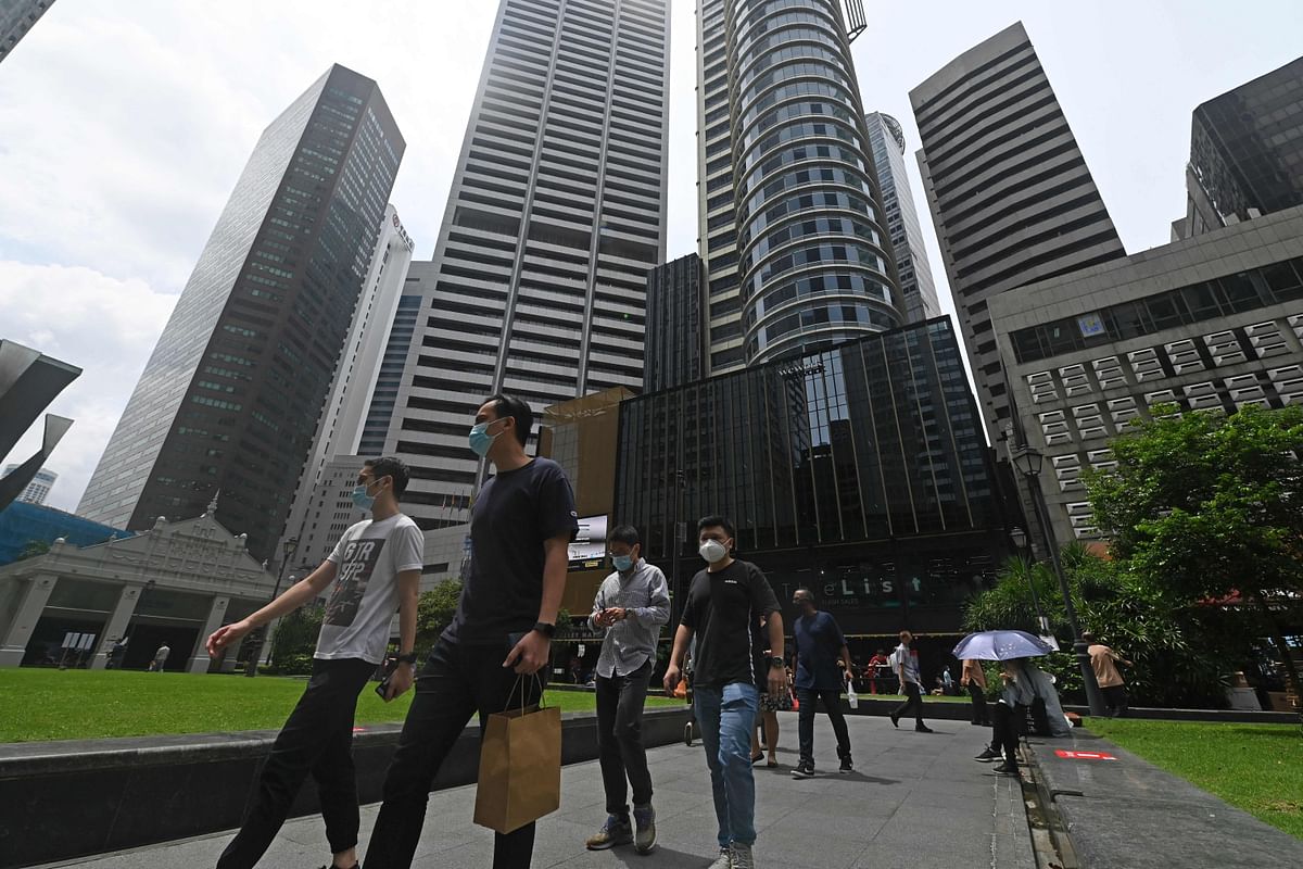 Office workers walk out during their lunch break at Raffles Place financial business district in Singapore. Credit: AFP Photo