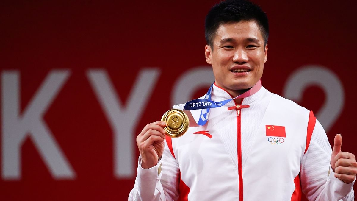 China's Lyu Xiaojun celebrates on the podium after winning the men's 81kg weightlifting competition. Credit: Reuters Photo