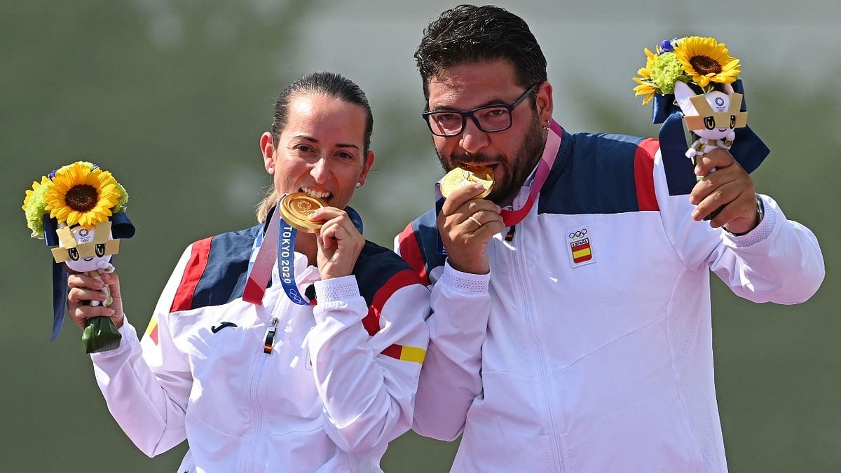 Gold medallists Spain's Fatima Galvez and Alberto Fernandez pose with their medals on the podium after the mixed team trap match. Credit: AFP Photo