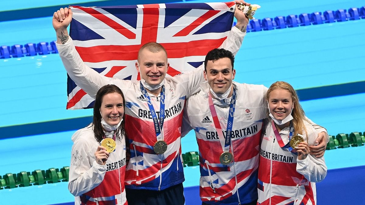 Gold medallists Britain's Kathleen Dawson, James Guy, Adam Peaty and Anna Hopkin and pose with their medals at the side of the pool. Credit: AFP Photo