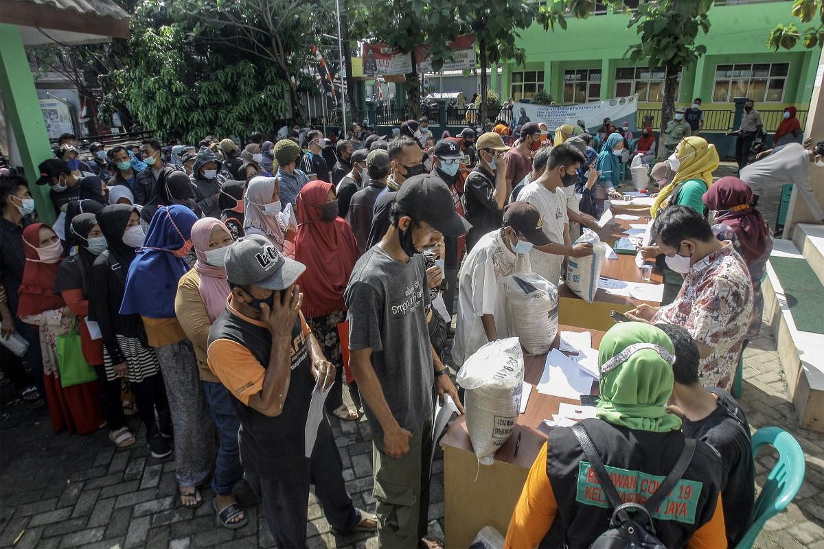 People affected during emergency restrictions stand in line to get social assistance of 10 kilograms amid the Covid-19 pandemic in Indonesia. Credit: Reuters Photo