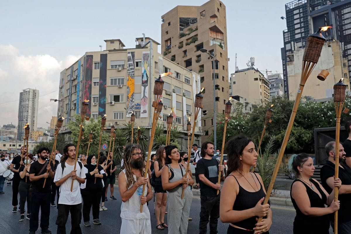 Protesters march with burning torches as they join families of the August 4 victims during a symbolic funeral procession from Beirut port. Credit: AFP Photo