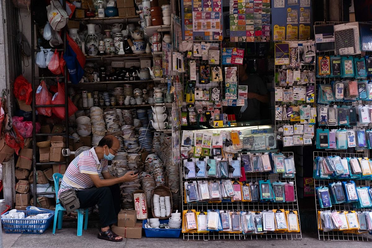 A street vendor looks at his phone at a tableware shop in Hong Kong’s Sai Ying Pun area. Credit: AFP Photo