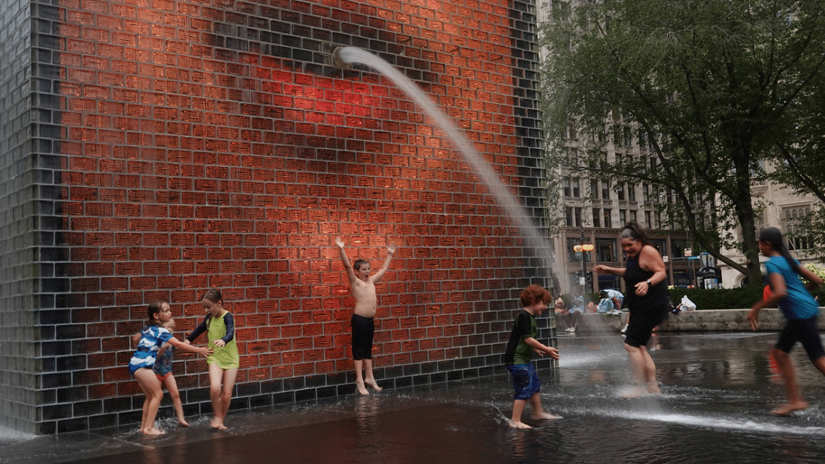 People cool off in Crown Fountain in Millennium Park in Chicago, Illinois as temperatures climb across the nation. Credit: AFP Photo