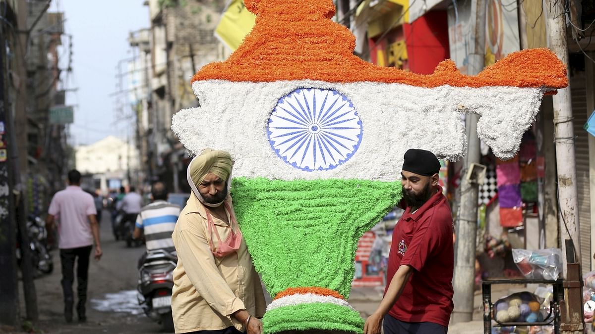 Artists carry a tricolour Indian map walk past ahead of Independence Day celebration in Jammu. Credit: PTI Photo