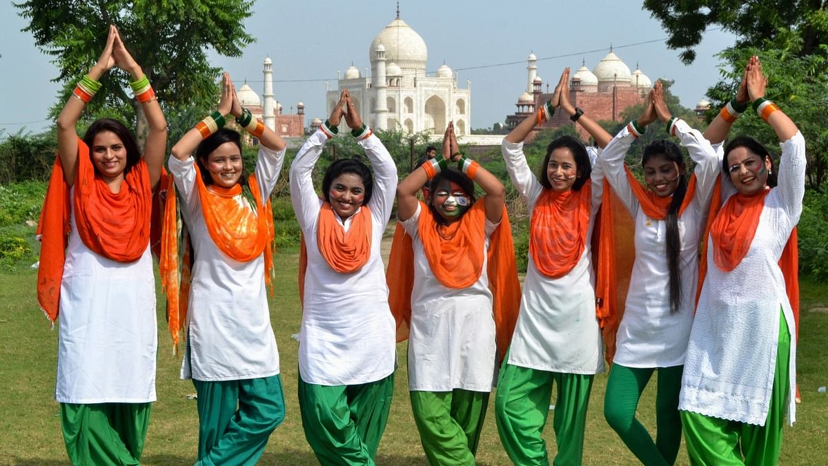 Girls wearing the tricolour, pose near Taj Mahal ahead of the 75th Independence Day, in Agra. Credit: PTI Photo