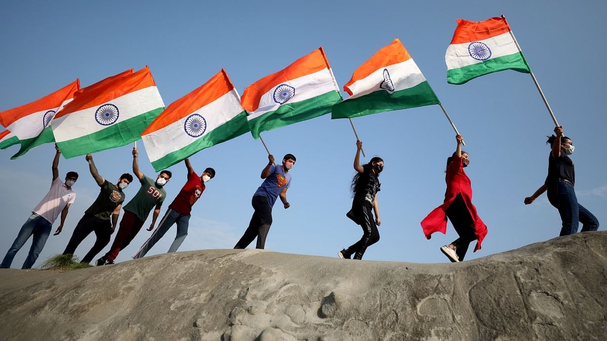 Youngsters run holding the flag ahead of 75th Independence Day celebrations, in Jammu. Credit: PTI Photo