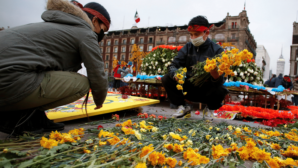 People arrange flowers for an offering to mark the 500th anniversary of the Fall of Tenochtitlan, at Zocalo square in downtown Mexico City, Mexico. Credit: Reuters Photo