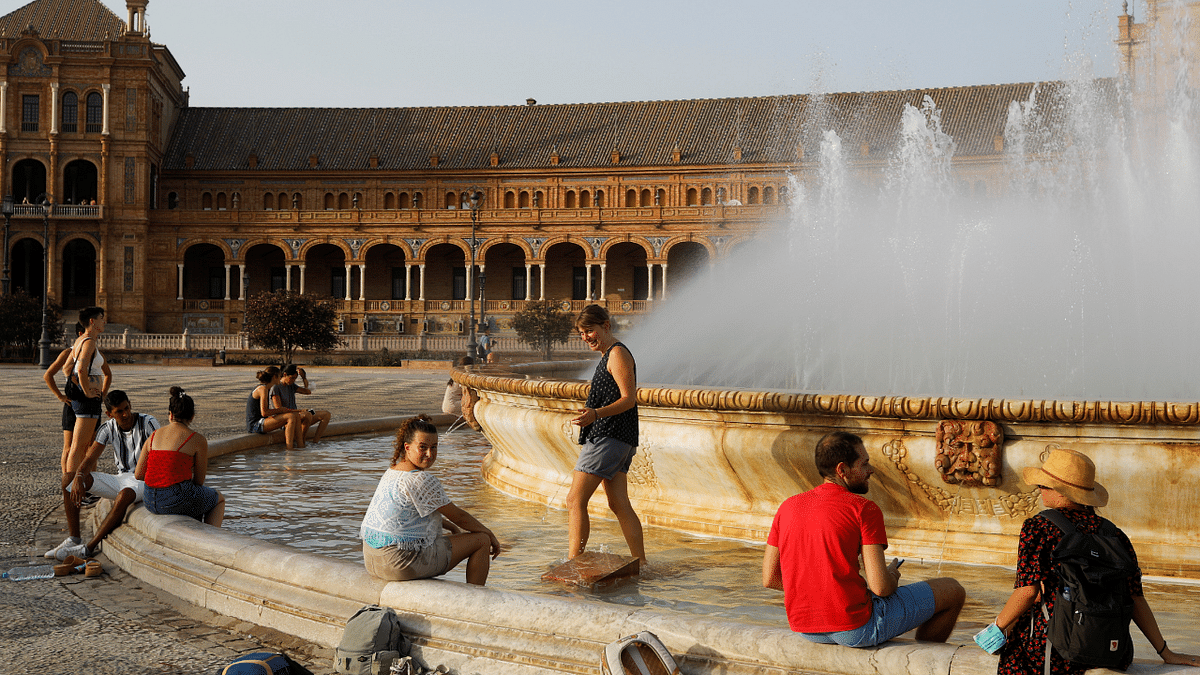 Tourists cool off in a fountain at the Plaza de Espana (Spain square), as a heatwave hits Spain, in Seville. Credit: Reuters Photo