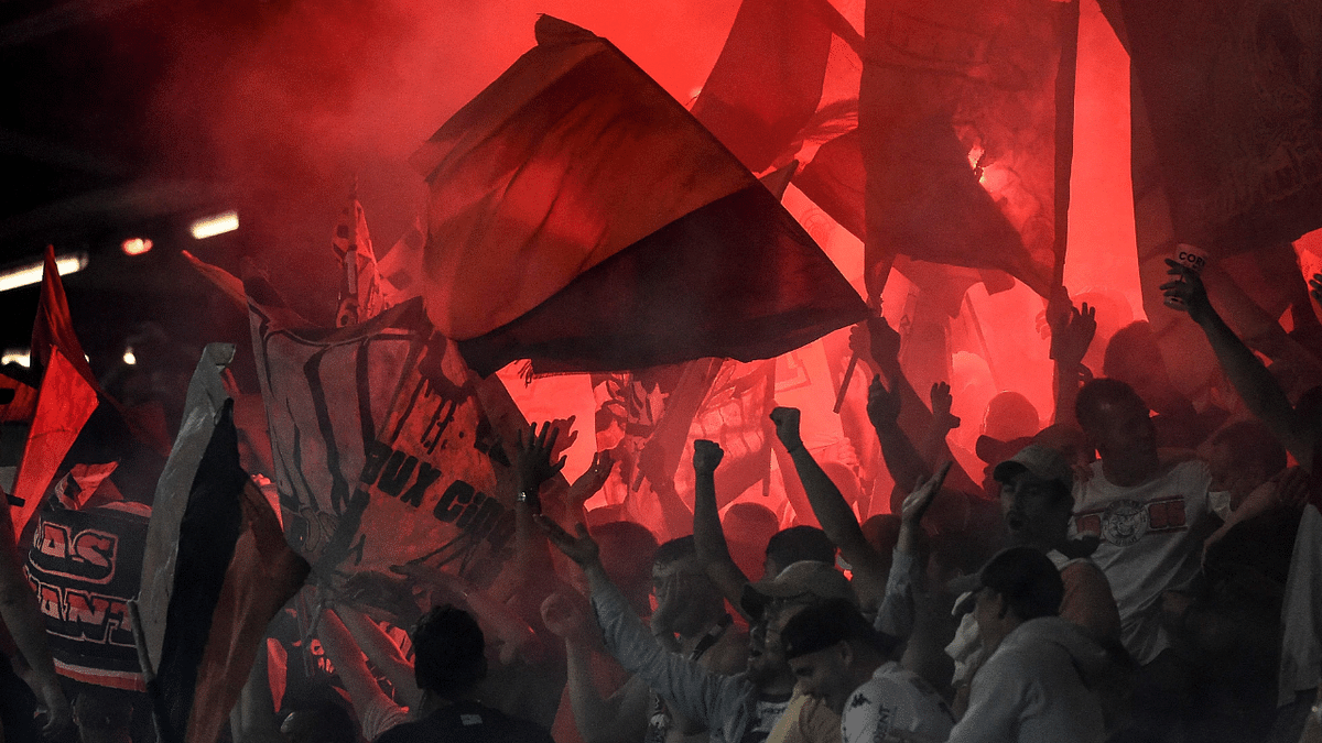 Lorient's supporters wave flags amid smoke of flares during the French L1 football match between Lorient and Monaco at Le Moustoir stadium in Lorient, western France. Credit: AFP Photo