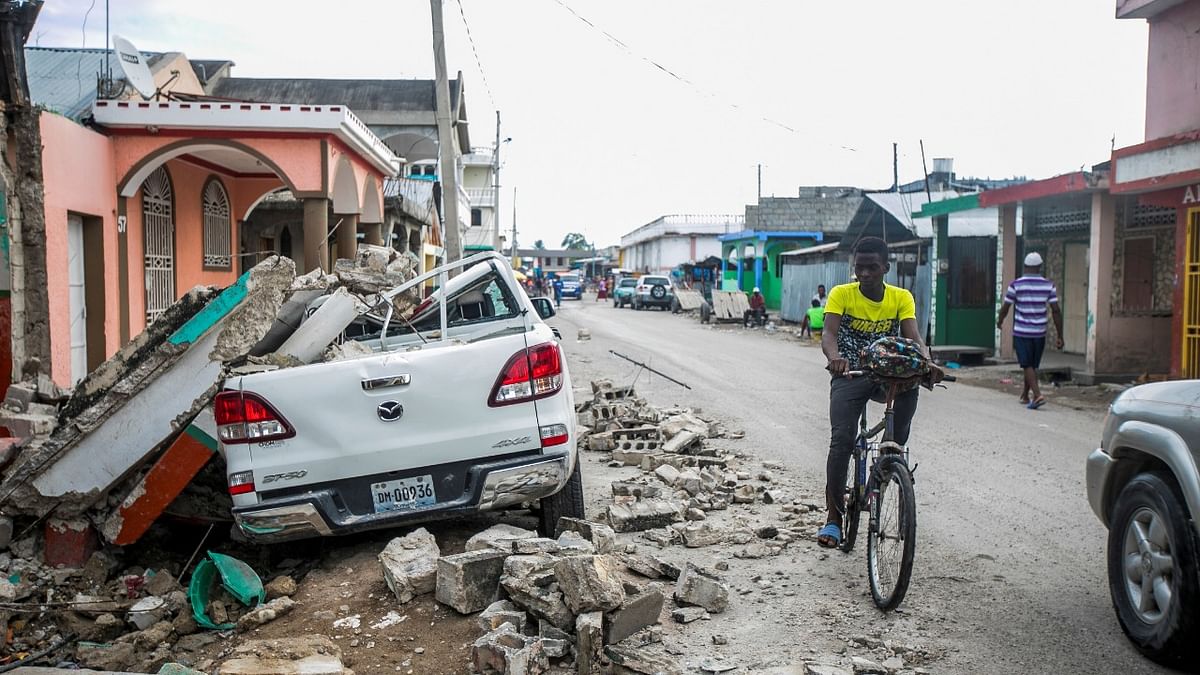 A car damaged is pictured under debris after a 7.2 magnitude earthquake in Les Cayes, Haiti. Credit: AFP Photo
