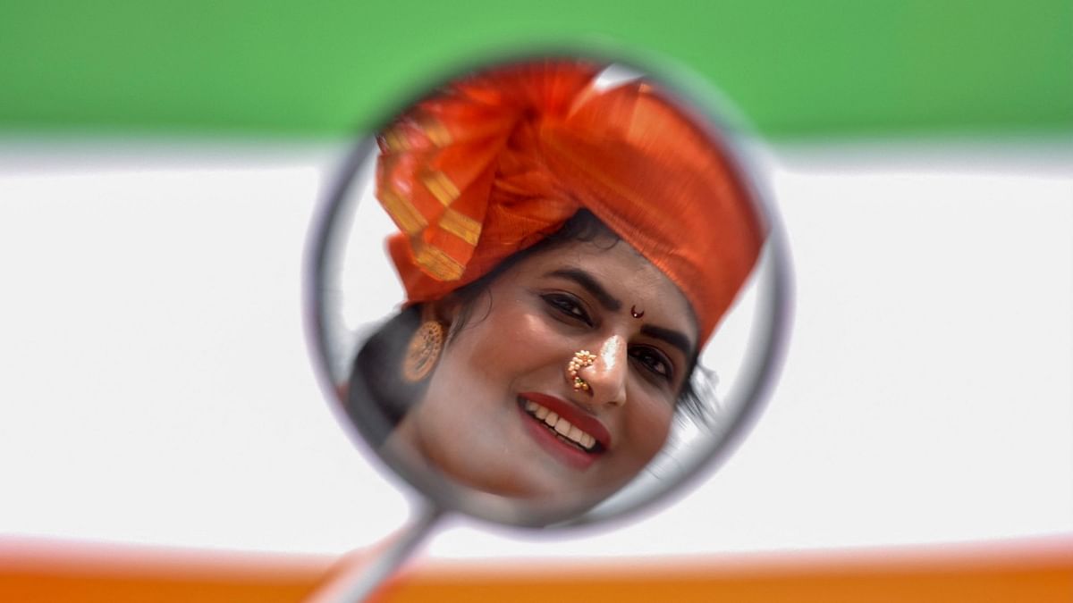 A woman dressed in traditional Maharashtrian attire poses for a photograph prior to a bike rally taken out on the occasion of the 75th Indian Independence Day celebrations in Bangalore. Credit: AFP Photo