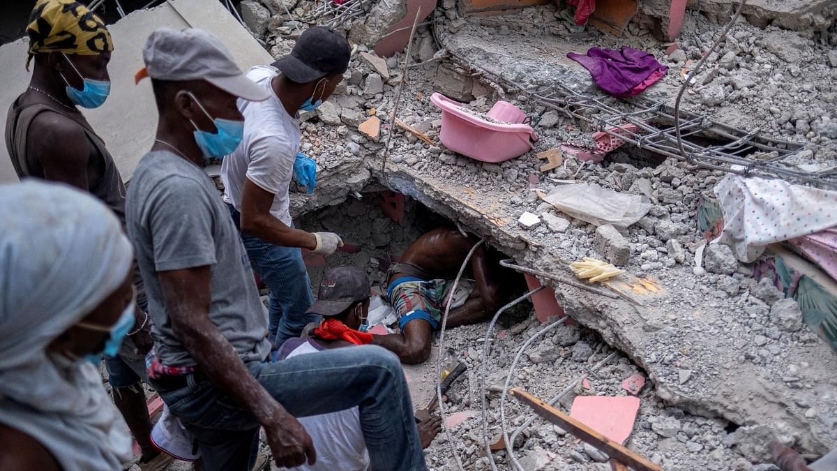 People search for survivors under the rubble of a destroyed hotel after 7.2 magnitude quake, in Les Cayes, Haiti. Credit: Reuters Photo