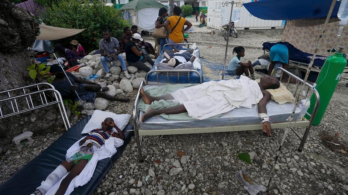Injured earthquake victims continued to stream into Les Cayes' overwhelmed general hospital, three days after the earthquake struck. Patients waited to be treated on stair steps, in corridors and the hospital's open veranda. Credit: Reuters Photo