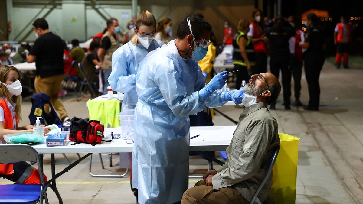 Spanish Red Cross conduct Covid-19 tests for Spanish and Afghan citizens who arrived at Torrejon airbase after evacuating from Kabul. Credit: Reuters Photo