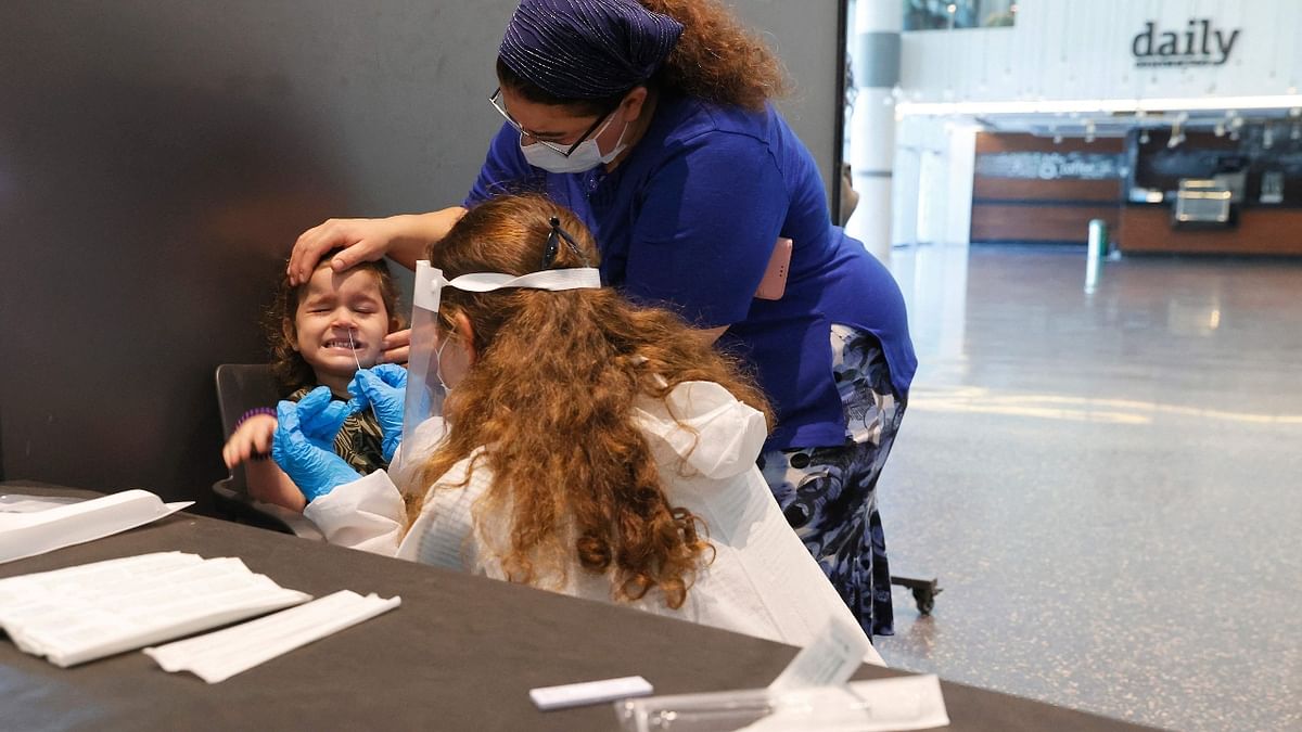 Israeli parents accompany their children to do an antigen test in order to visit the