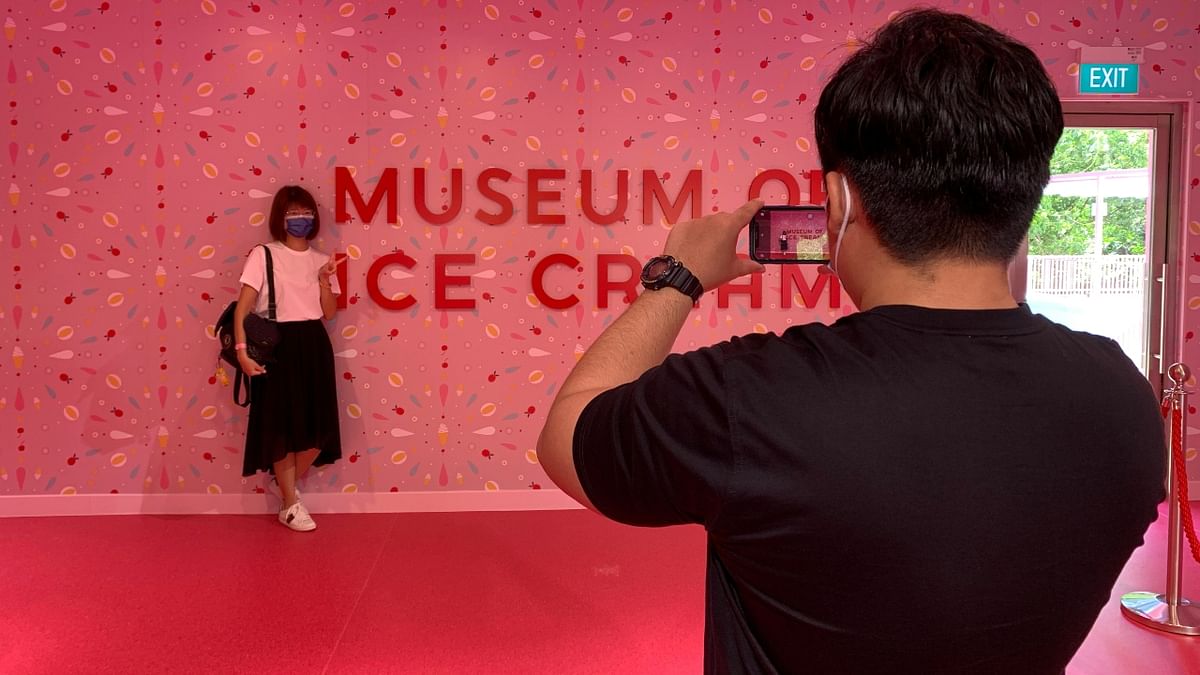 Tourists take pictures in front of a sign at the entrance of the Museum of Ice Cream in Singapore. Credit: Reuters Photo