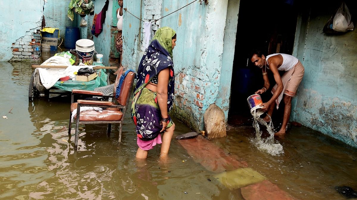 A man removes water from his waterlogged house after rain at Jahangirpuri area in New Delhi. Credit: PTI Photo