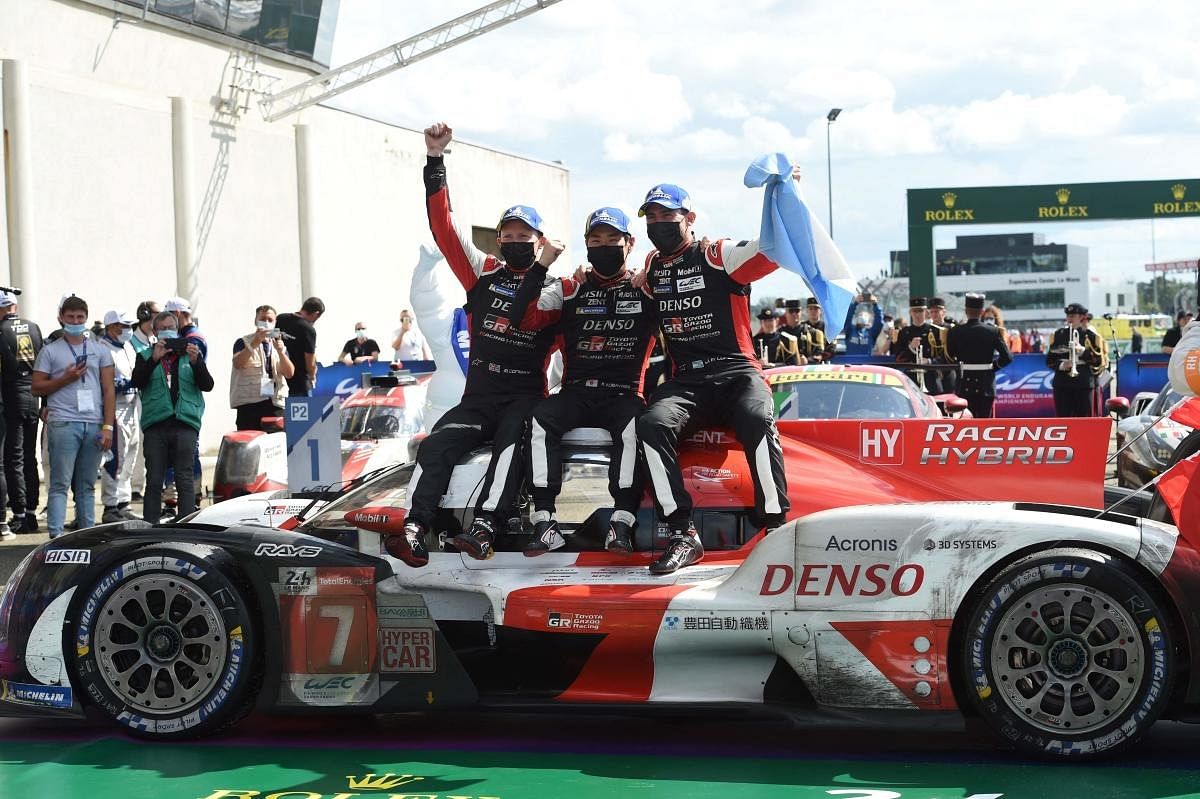 Toyota TS050 Hybrid Hypercar WEC's British driver Mike Conway, Japanese driver Kamui Kobayashi and Argentine driver Jose Maria Lopez celebrate on their car after winning the 89th edition of the Le Mans 24 Hours endurance race. Credit: AFP Photo