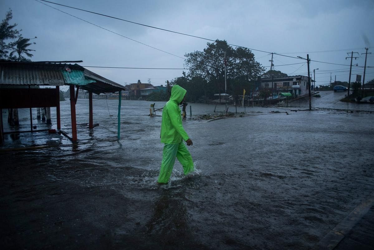 A man walks in a flooded street due to heavy rains caused by Hurricane Grace in Tecolutla, Veracruz, Mexico. Credit: AFP Photo