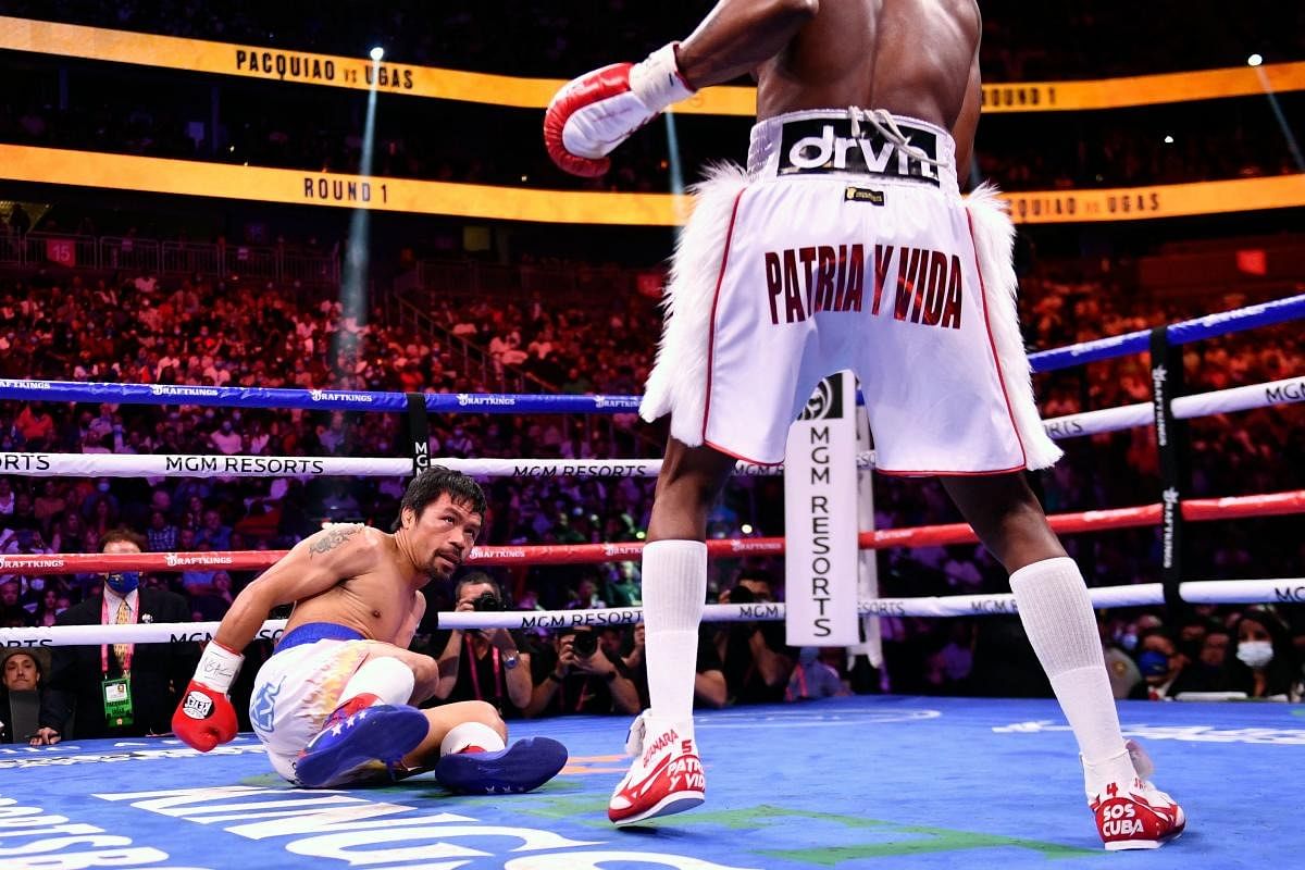 Manny Pacquiao of the Philippines (L) looks at Yordenis Ugas of Cuba after being knocked down during the WBA Welterweight Championship boxing match at T-Mobile Arena in Las Vegas, Nevada. Credit: AFP Photo