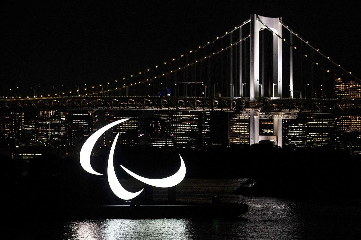 The Paralympics symbol is seen lit up at night with the Rainbow bridge in the background, on the Odaiba waterfront in Tokyo. Credit: AFP Photo