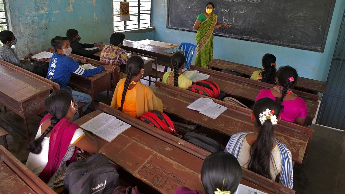 Students of a government school attend their class on the first day of reopening of schools for the higher secondary classes with 50 percent capacity after 18 months of closure due to Covid-19  pandemic in Bengaluru. Credit: AFP Photo