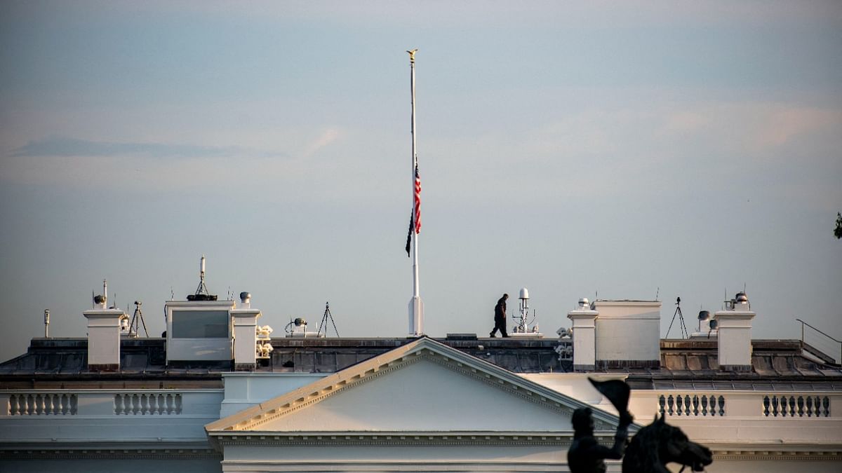 A secret service officer walk back after lowering the US flag that flies at half mast over the White House after US President Joe Biden delivered remarks on the terror attack at Hamid Karzai International Airport, and the US service members and Afghan victims killed and wounded, in Washington, DC. Credit: AFP Photo