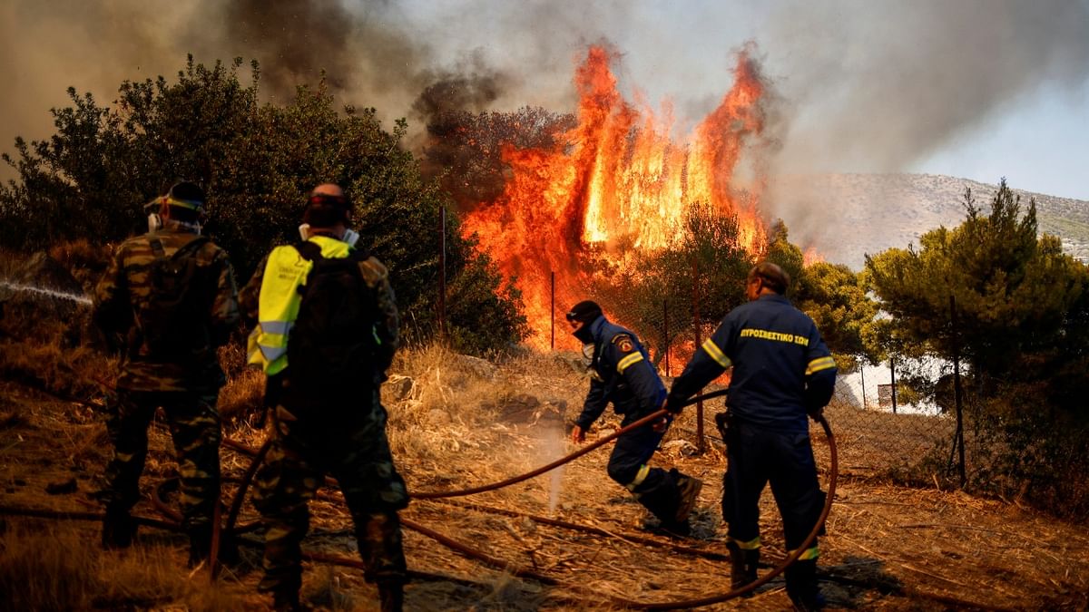 Firefighters and volunteers try to extinguish a wildfire burning in the village of Markati, near Athens, Greece. Credit: Reuters Photo