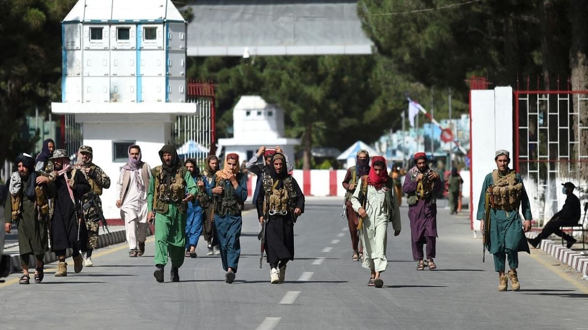 Taliban fighters walk at the main entrance gate of Kabul airport in Kabul on August 28, 2021. Credit: AFP Photo